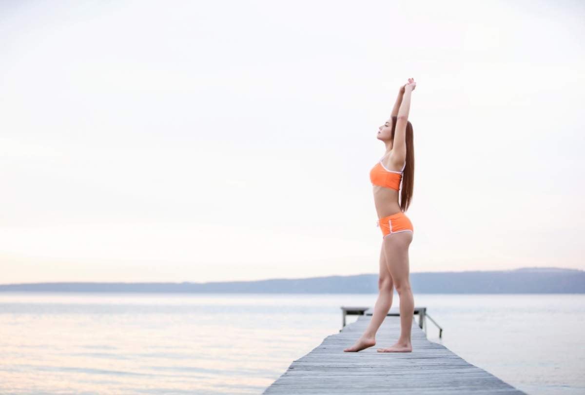 ragazza fa stretching vicino al mare