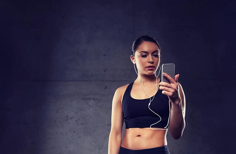 woman-with-smartphone-and-earphones-in-gym-P6VKABY (1)