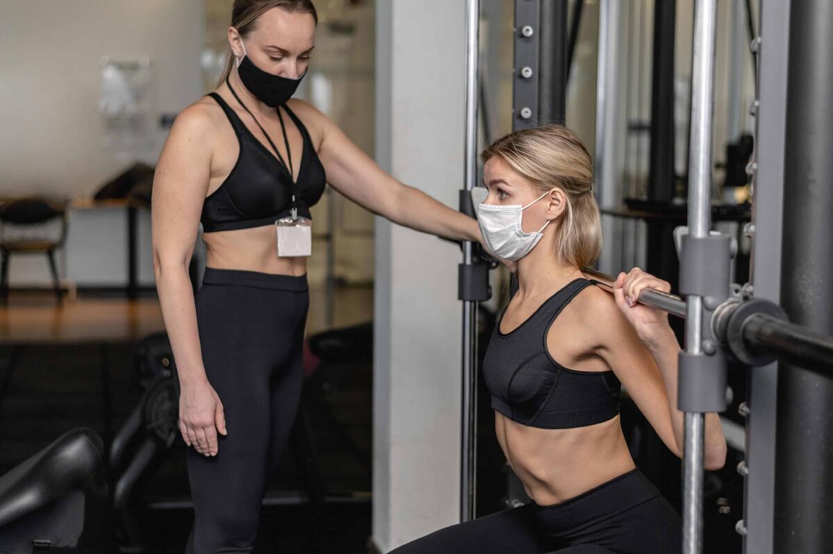 due donne si allenano in palestra con la mascherina