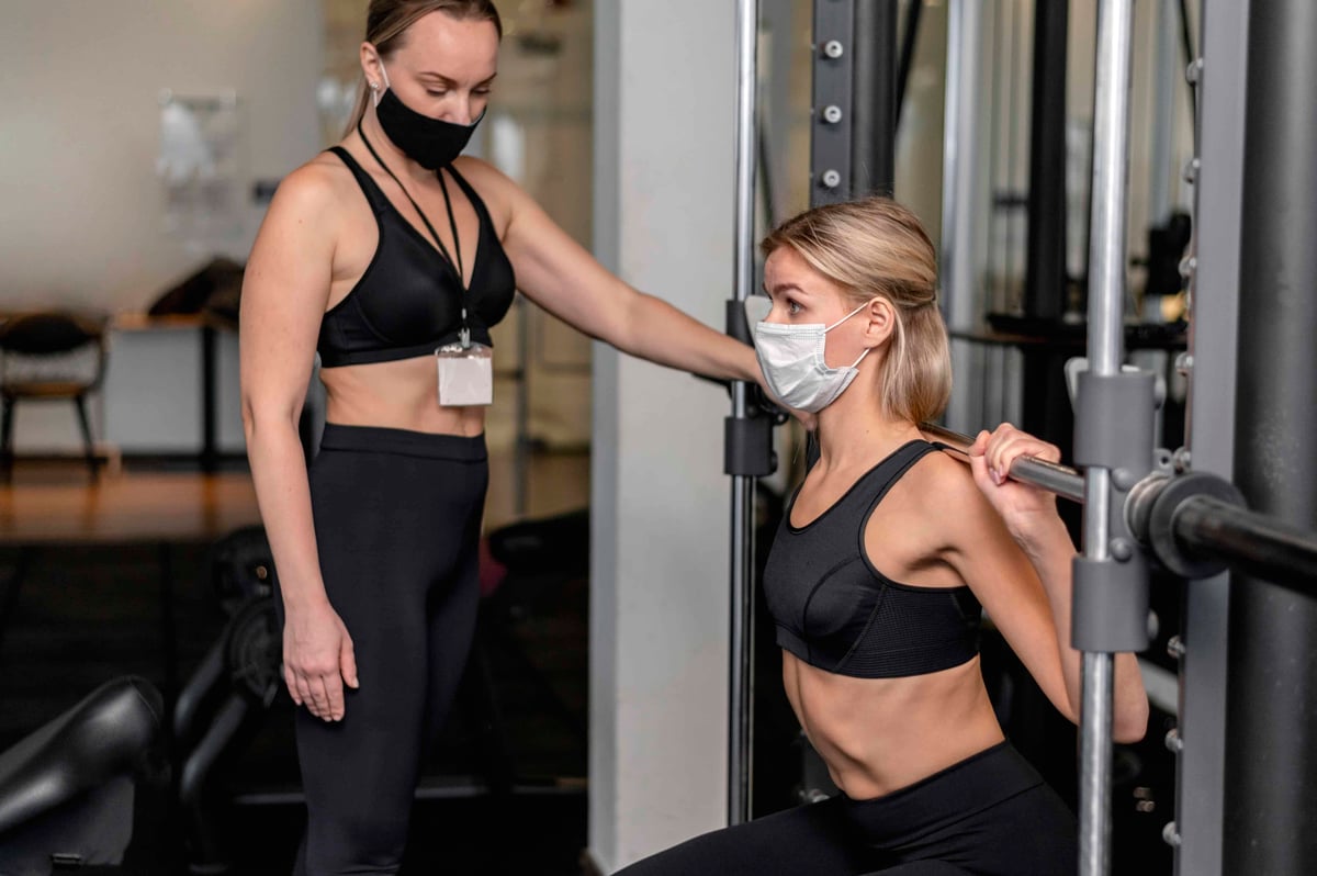 due donne si allenano in palestra con la mascherina